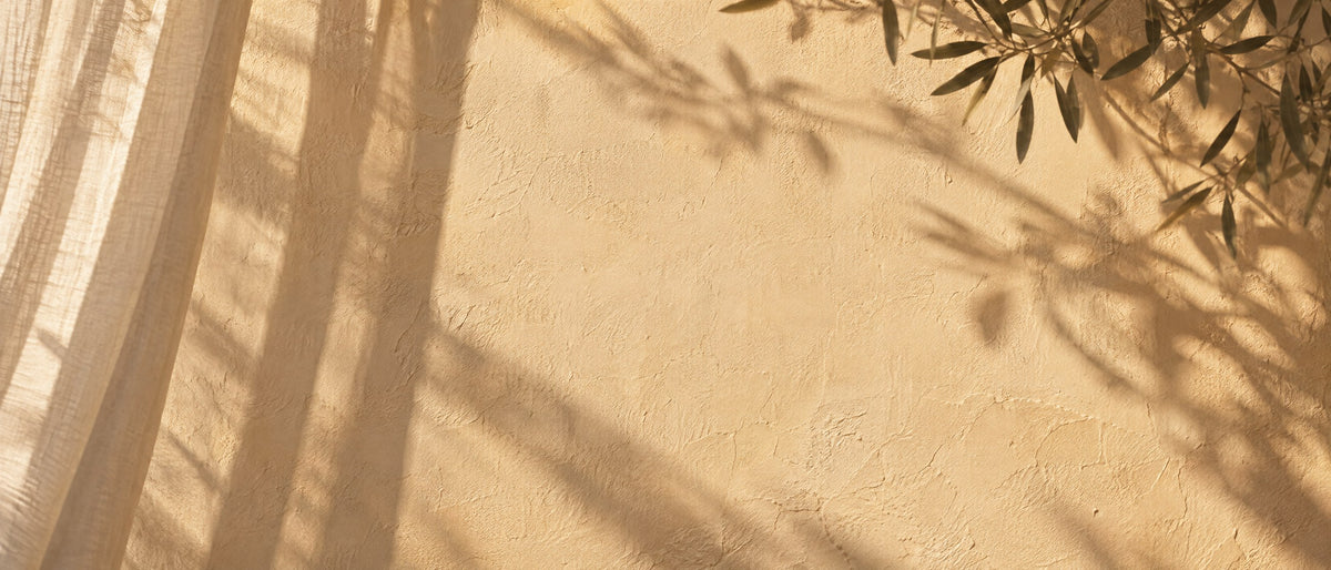 Sheer curtain shadows falling across a warm plaster wall in late sun